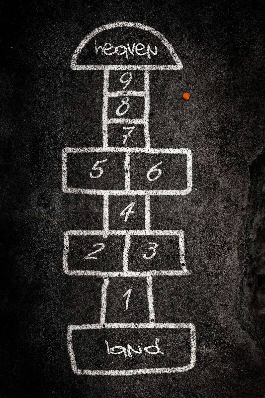 Hopscotch game designed on the road with chalk, stock photo