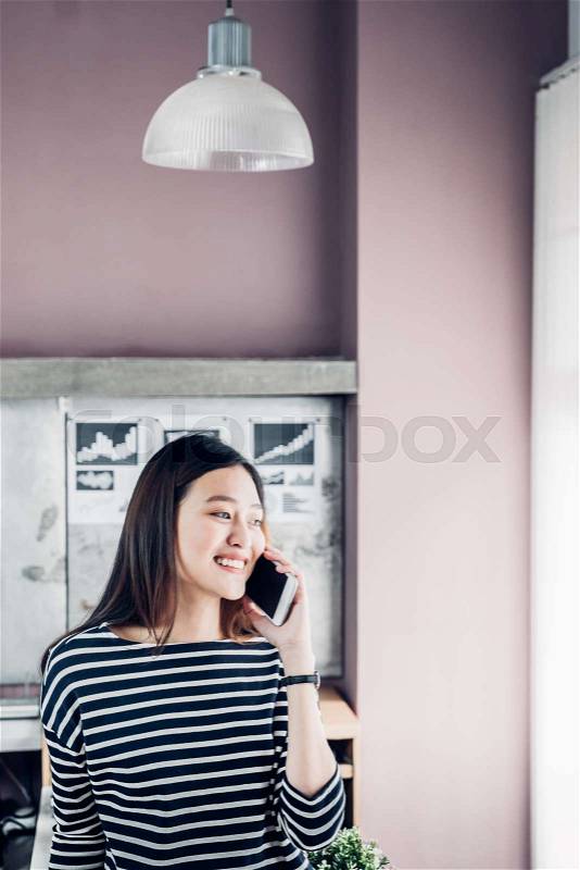 Asia businesswoman owner wear casual cloth talking on mobile phone in home office working space for contact customer,office lifestyle with technology, stock photo