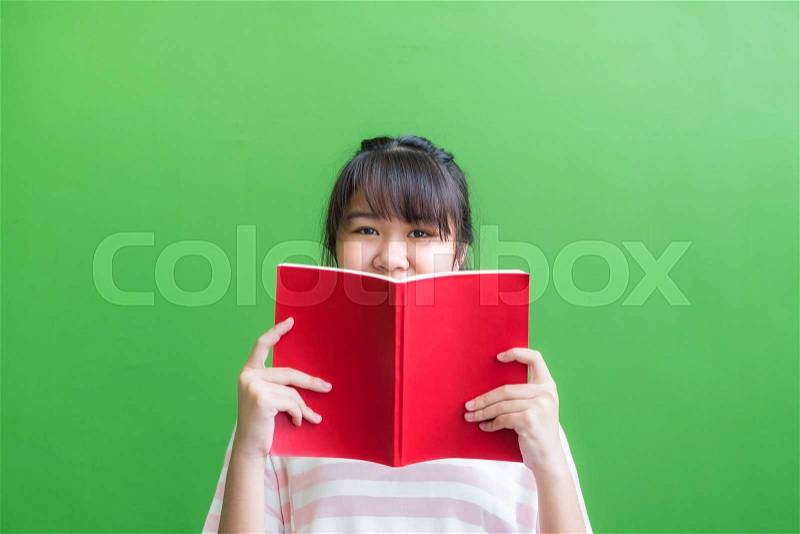 Teenager asia girl holding red book cover face with thinking action against green vivid wall,Leave copy space upper head to adding content of design for advertising education campaign concept., stock photo