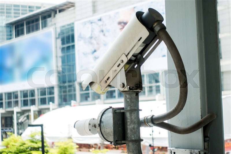 Surveillance Security Camera or CCTV in for protection system under the bridge and blur background with building, copy space, stock photo