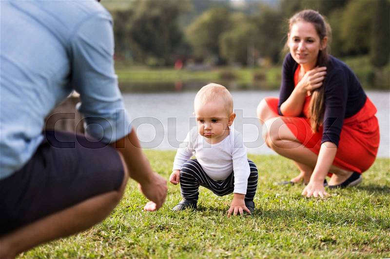 Cute little boy making first steps in nature. Young family spending time in nature. Summer time, stock photo