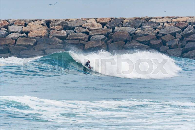 Bodyboarder surfing ocean wave on a sunny day, stock photo
