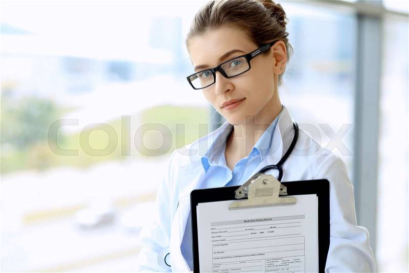 Medical physician doctor woman over blue clinic background, stock photo