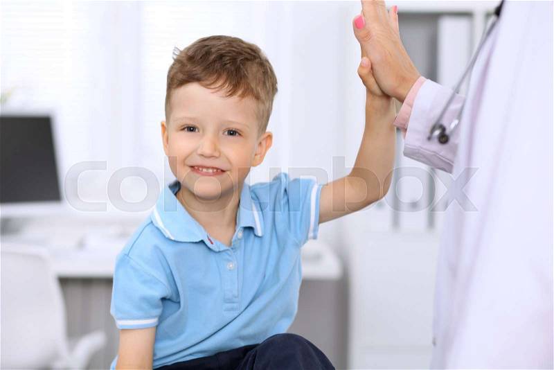 Happy little boy giving high five after health exam at doctor\'s office, stock photo
