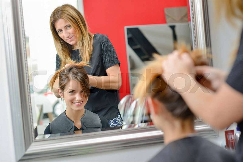 Lady having hair styled in hairdressers, stock photo