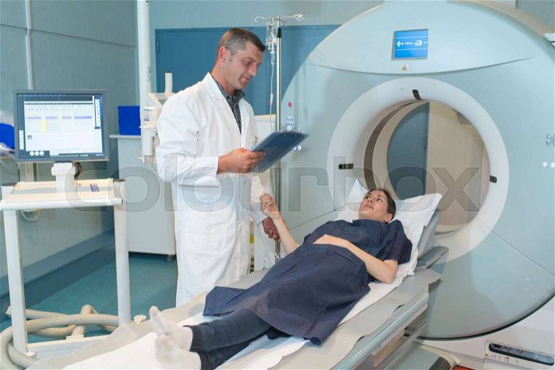 Happy patient undergoing mri scan at hospital, stock photo