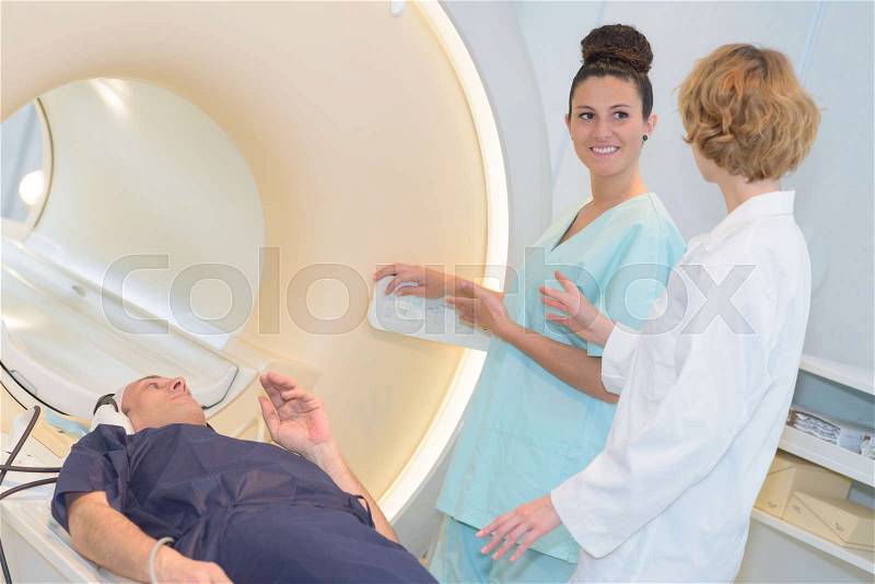 Medical staff talking beside mri scanner, stock photo