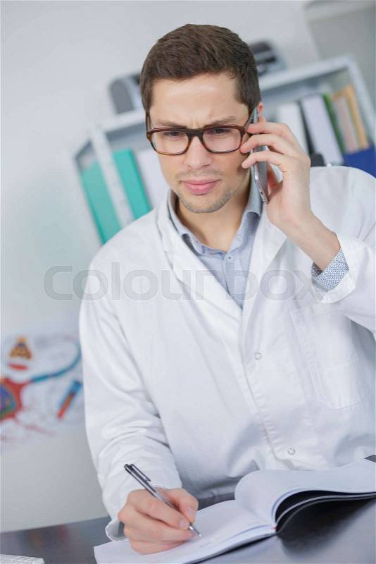 Portrait of physiotherapist talking on mobile phone in clinic, stock photo