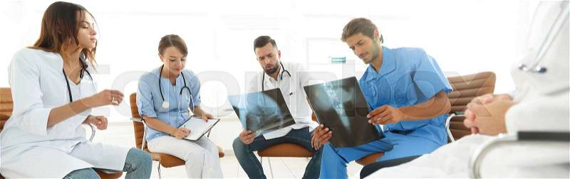 Group of surgeons and medical professional staff discussing on patient radiography in the office, stock photo