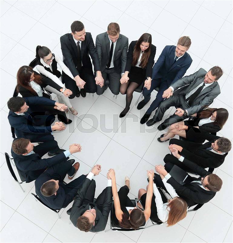 Concept of team building.large business team sitting in a circle and holding each other\'s hands, stock photo