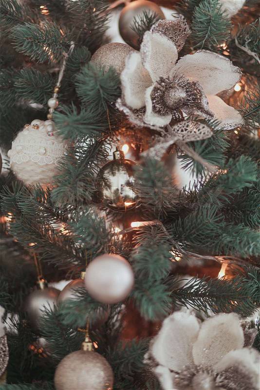 Group of silver and gold vintage Christmas toys weigh on green branches Christmas tree closeup, stock photo