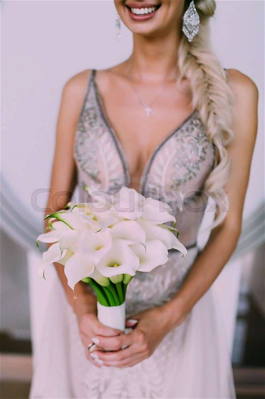 Beautiful wedding bouquet of calla flowers in hands of the bride. Artwork. Soft focus on a bouquet. Outdoor, stock photo