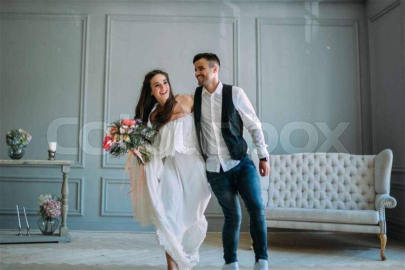 Cheerful bride and groom having fun together. Newlyweds laughing and go crazy. Artwork. Wedding indoors. Close-up. Selective, soft focus, stock photo