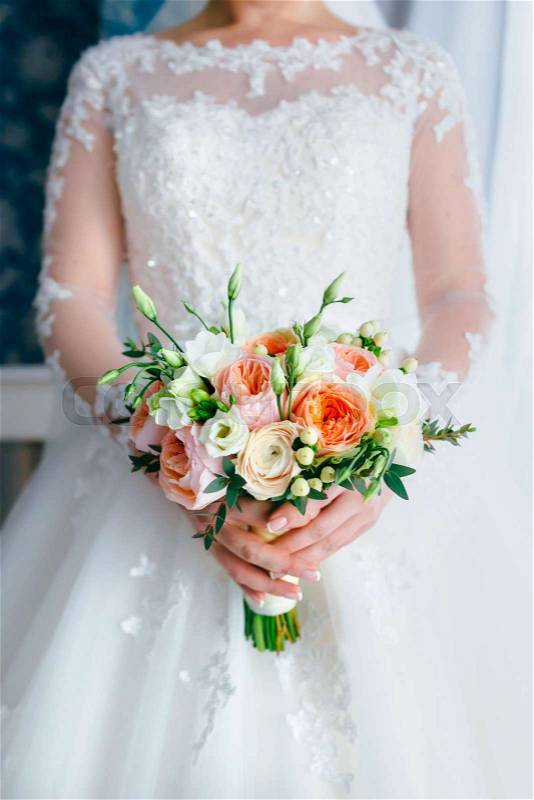 Beautiful bridal bouquet with white roses and peach peonies in a bride hands in white dress. Wedding morning. Close-up, indoor, stock photo