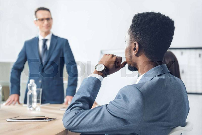 Handsome african american businessman listening to boss on conversation, stock photo