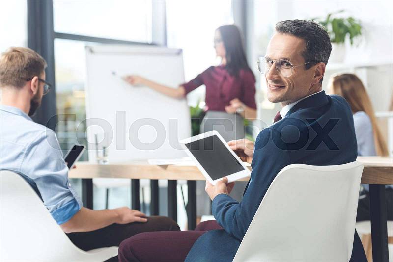 Handsome businessman with digital tablet at conference hall, stock photo