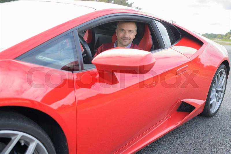 Lucky man driving a red lamborghini, stock photo