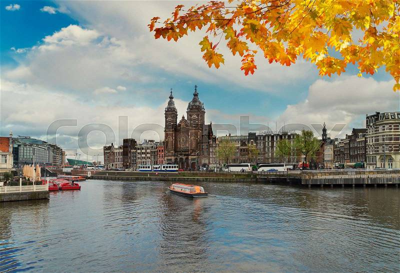Amsterdam skyline with Church of St Nicholas over old town canal, Amsterdam, Holland at autumn day, stock photo