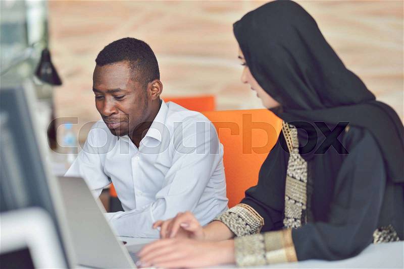 Multiracial contemporary business people working connected with technological devices like tablet and laptop, talking together - finance, business, technology concept, stock photo