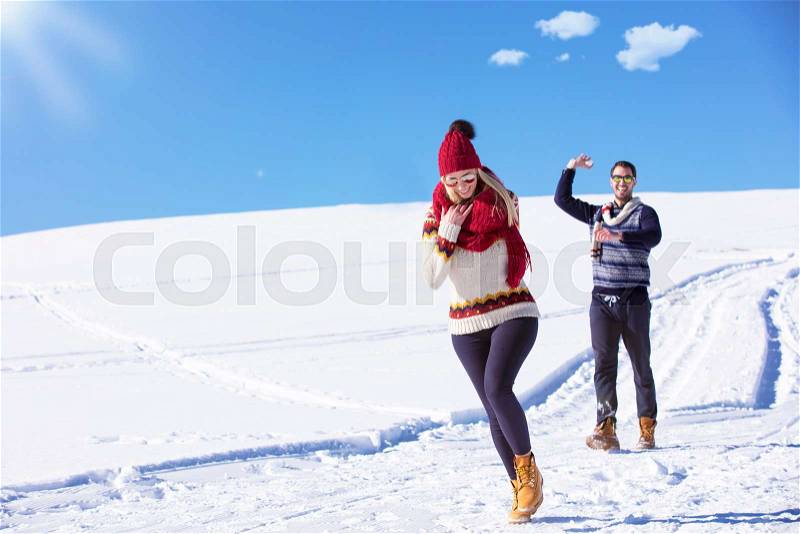 Carefree happy young couple having fun together in snow, stock photo