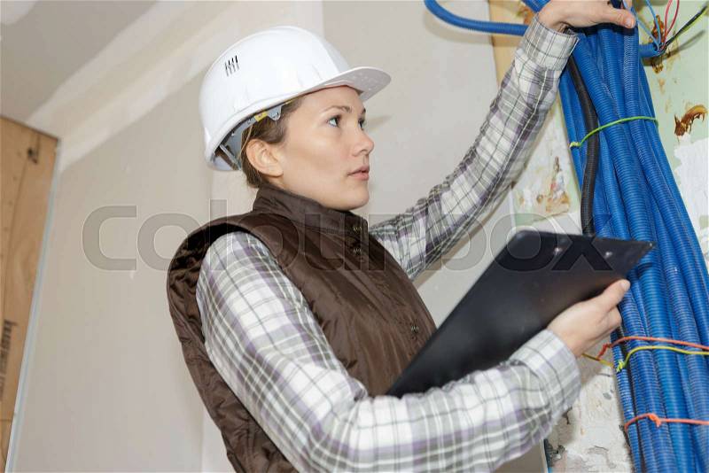 Engineer checking the temperature pipes in a construction site, stock photo