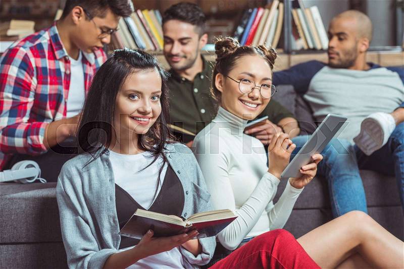 Happy multiethnic students studying together and smiling at camera, stock photo