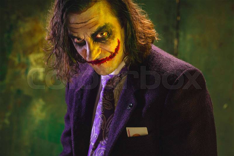 Bloody Halloween theme: The crazy maniak face on dark studio background, stock photo