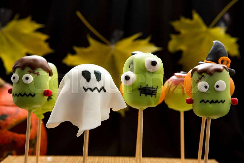 Sweet Halloween cake pops. Horror cake pops in shape of ghosts and monsters. Autumn background, stock photo