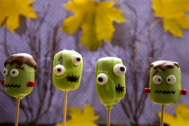 Sweet Halloween cake pops. Horror cake pops in shape of ghosts and monsters. Autumn background, stock photo