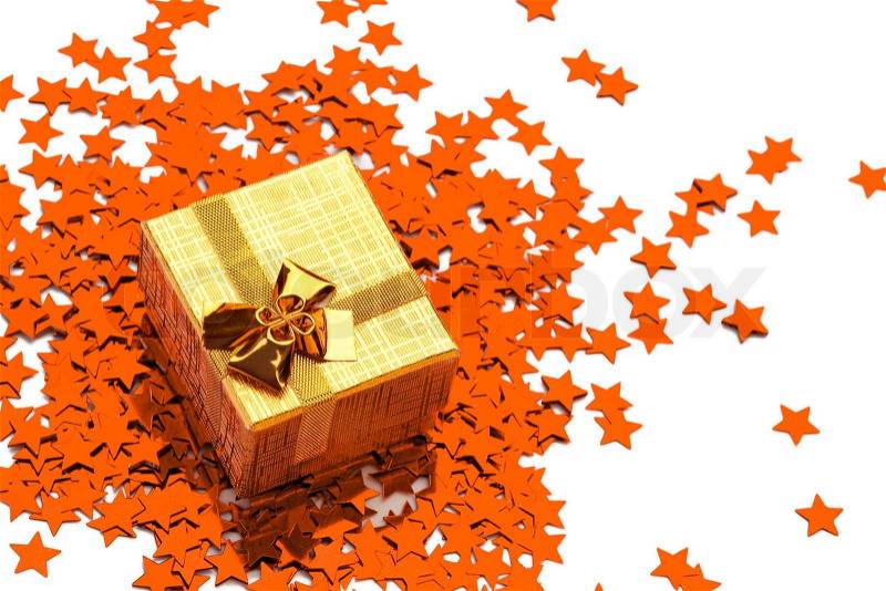 Small box is standing on scattered ornamental star, stock photo