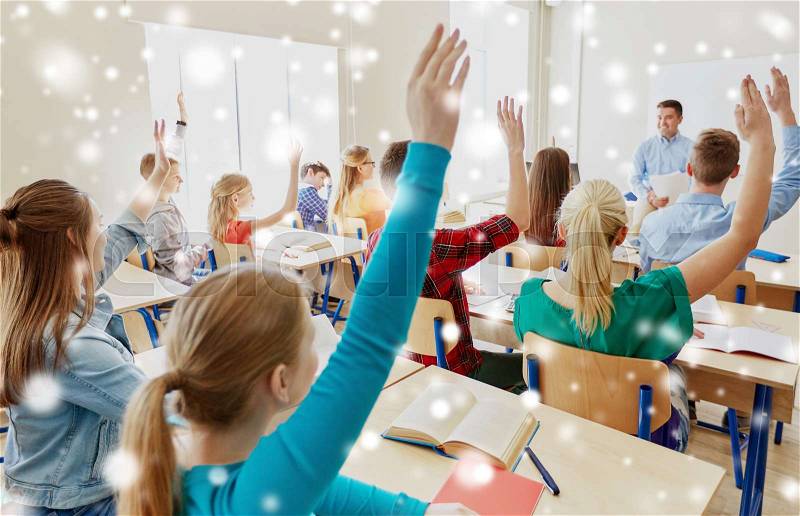 Education, school and people concept - group of students raising hands and teacher with papers or tests over snow, stock photo
