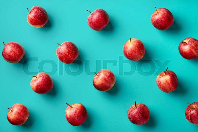 Colorful fruit pattern of fresh red apples on blue background. From top view, stock photo