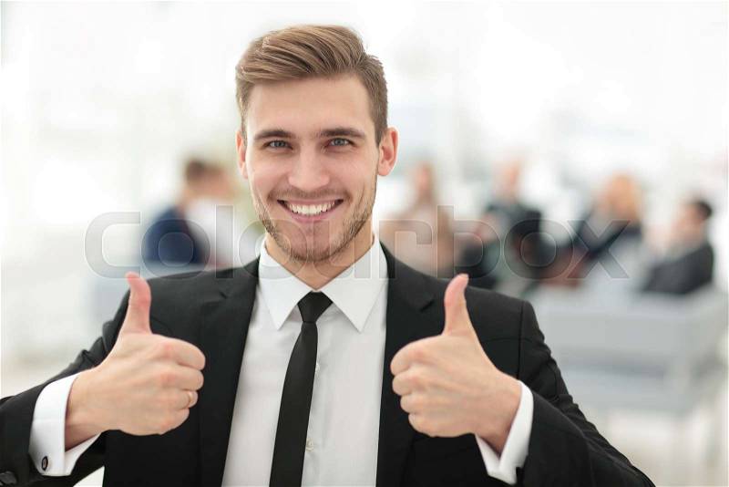 Successful businessman showing thumbs up. photo blurred background, stock photo