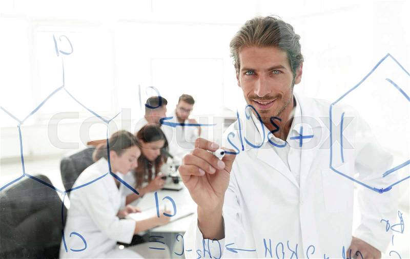 View through the transparent Board. smiling scientist records data on a glass Board, stock photo