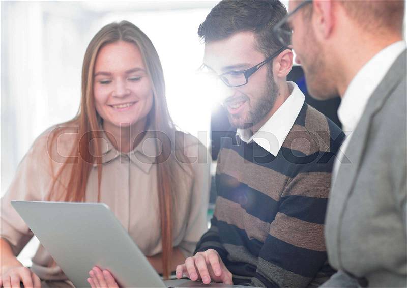 Three happy employees working on line with a tablet at office, stock photo