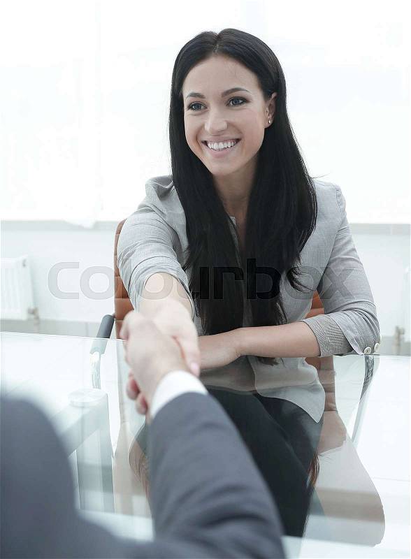 Handshake of a young woman with a business partner in the office. Photo with blank space for text, stock photo