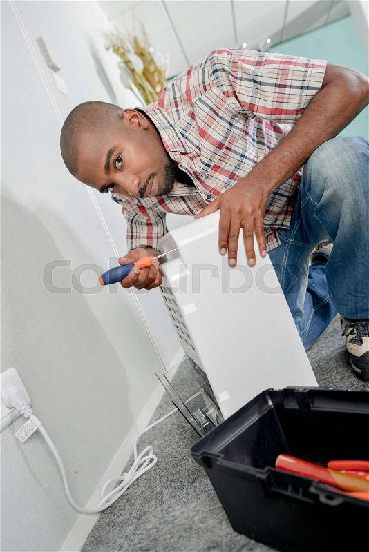 Man working on electrical appliance, stock photo