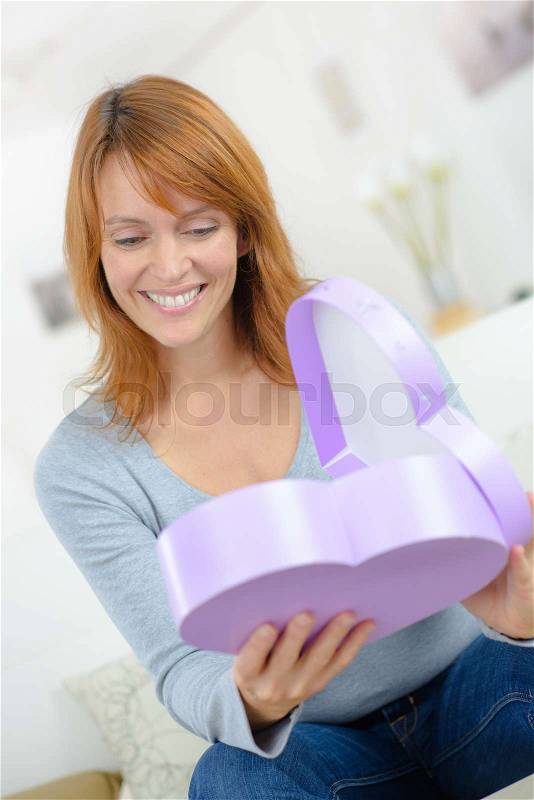 Happy surprised woman opening gift box, stock photo