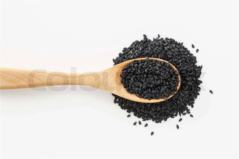 Black sesame on spoon on white background top view, stock photo