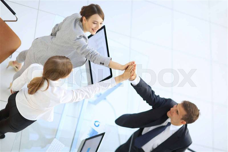 View from the top.members of the business team giving each other a high five above the Desk, stock photo