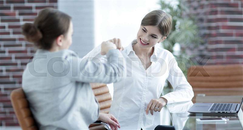 Happy employees are happy with the obtained results and give each other a fist bump, stock photo