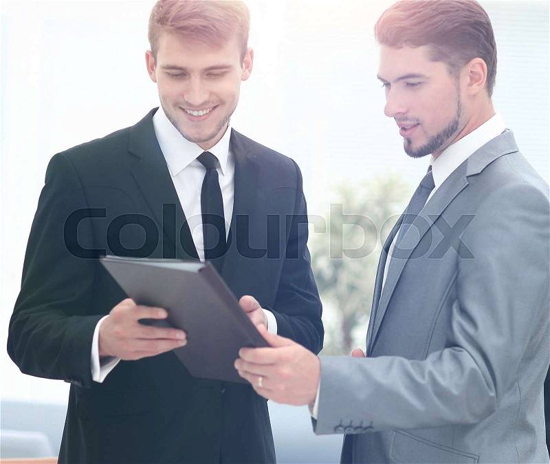 Two successful business partners discussing documents and ideas at meeting, stock photo