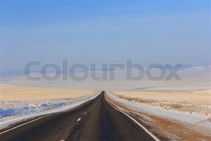 Winter road leaving into distance into the mountains, stock photo