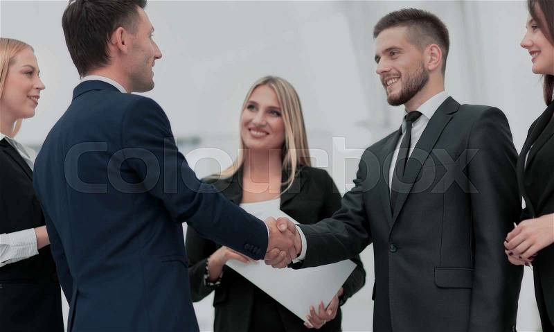 Handshake business partners and business team meeting in office, stock photo