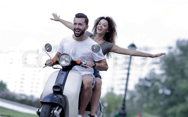 Happy couple driving scooter excited on summer holidays vacation, stock photo