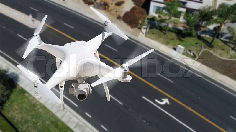 Unmanned Aircraft System (UAV) Quadcopter Drone In The Air Over Roadway, stock photo