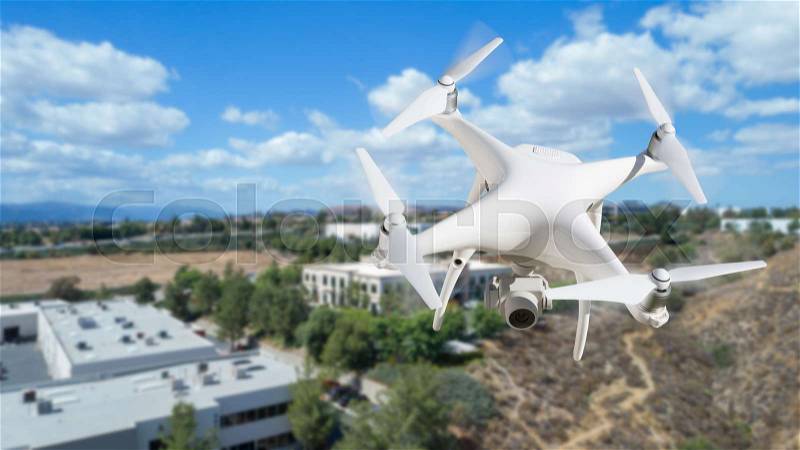 Unmanned Aircraft System (UAV) Quadcopter Drone In The Air Over Commercial Buildings, stock photo
