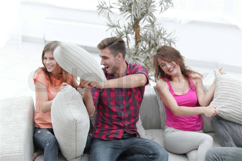 Group of friends playing pillow fight, sitting on the couch.photo with copy space, stock photo