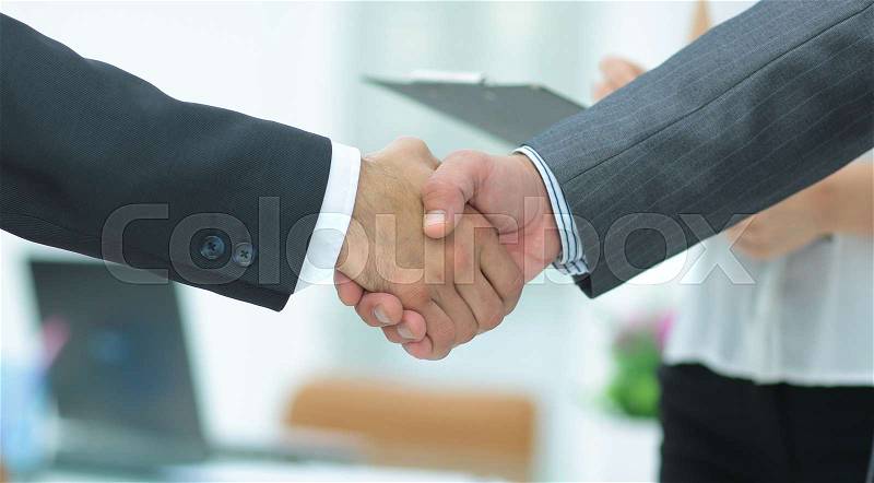 Good deal. Close-up of two business people shaking hands while sitting at the working place, stock photo