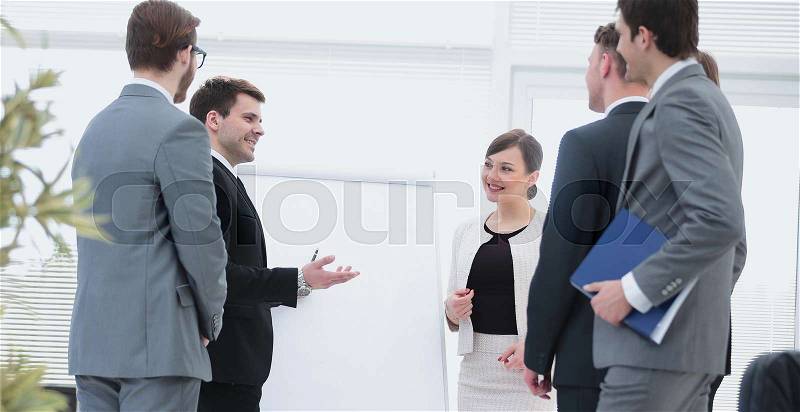 Smiling colleagues smiling while discussing something in modern office, stock photo